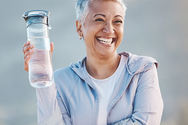 女人用水瓶站在小路